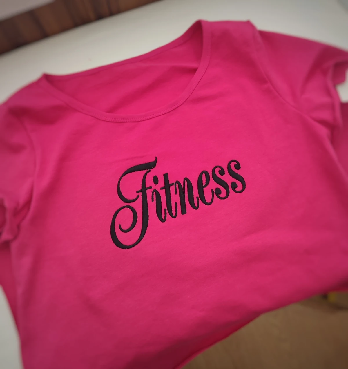 Чёрная машинная вышивка Fitness на розовой футболке
